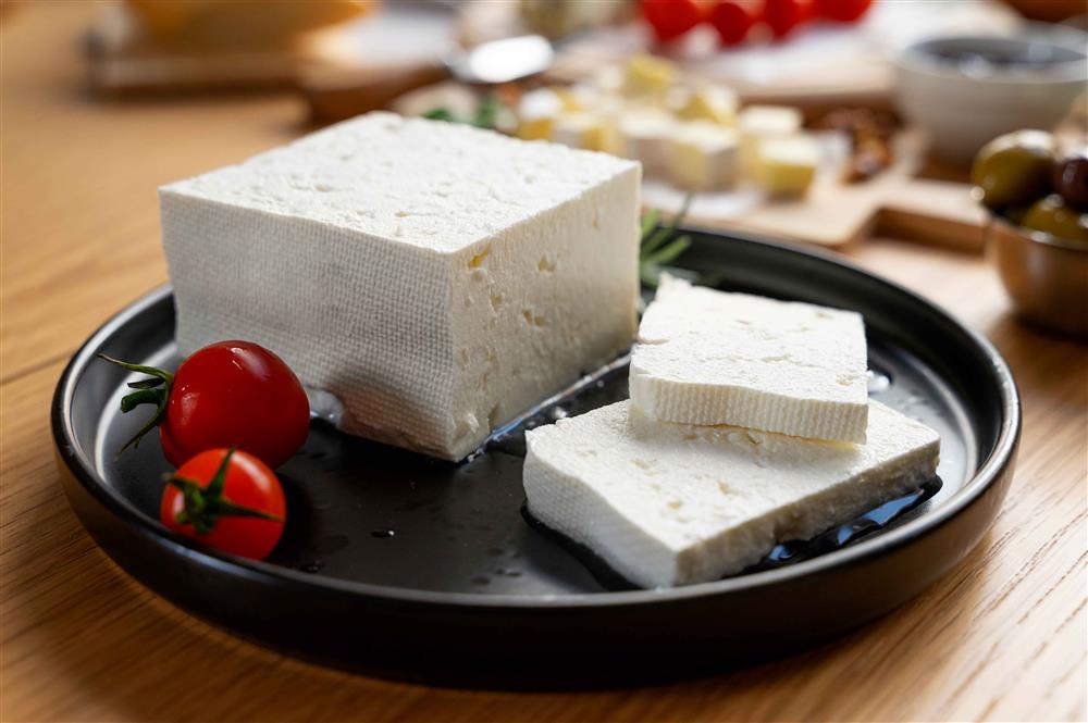 A slice of cheese and two tomatoes on a plate